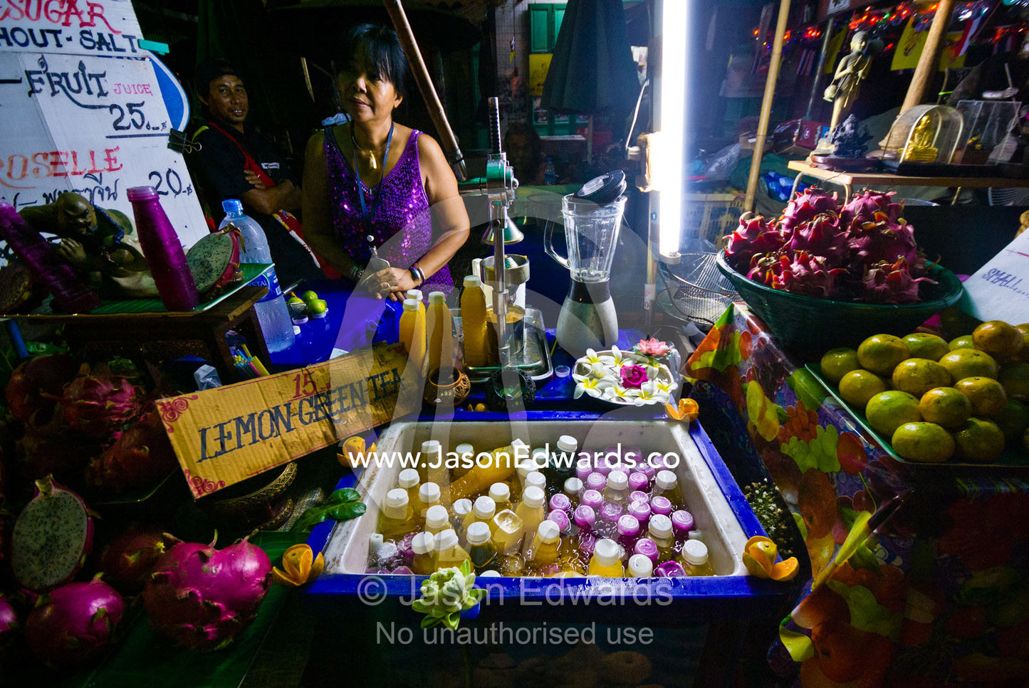 A night market sells freshly squeezed Dragon Fruit and Orange juice. Phra Nakhon District, Rattanakosin District, Bangkok, Thailand.