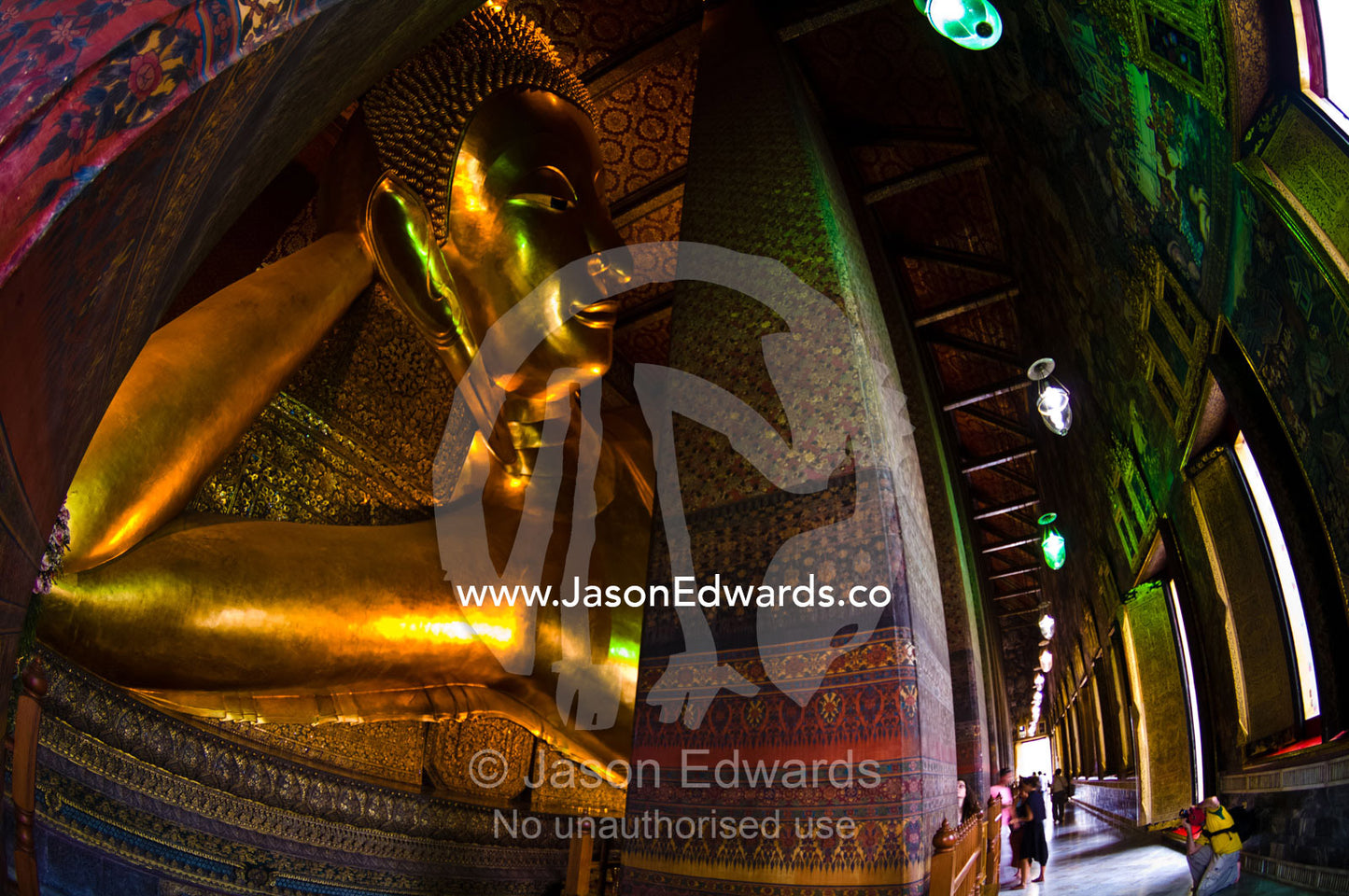 Worshippers pray to a statue of the Reclining Buddha in a vihara. Wat Pho, Temple of the Reclining Buddha, Wat Chetuphon, Phra Nakhon District, Rattanakosin District, Bangkok, Thailand.
