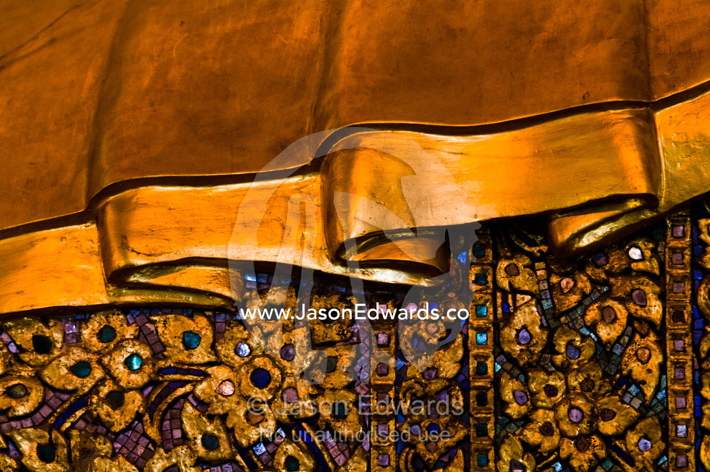 A detail of the golden and inlay robe worn by the Reclining Buddha. Wat Pho, Temple of the Reclining Buddha, Wat Chetuphon, Phra Nakhon District, Rattanakosin District, Bangkok, Thailand.