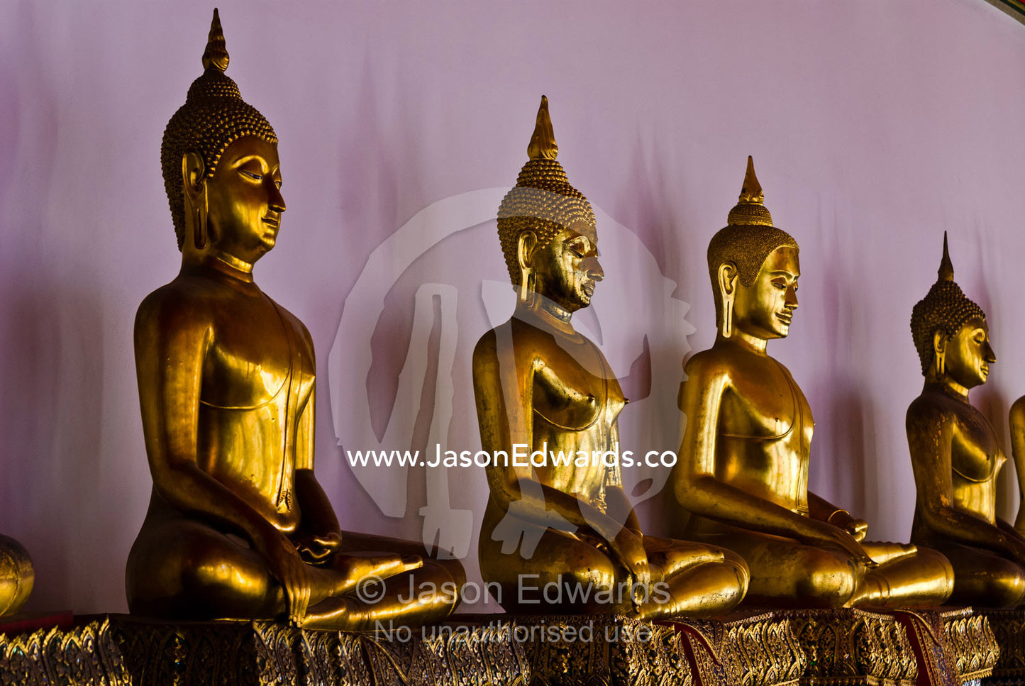 Gilded golden statues of the Buddha seated in a temple. Wat Pho, Temple of the Reclining Buddha, Wat Chetuphon, Phra Nakhon District, Rattanakosin District, Bangkok, Thailand.