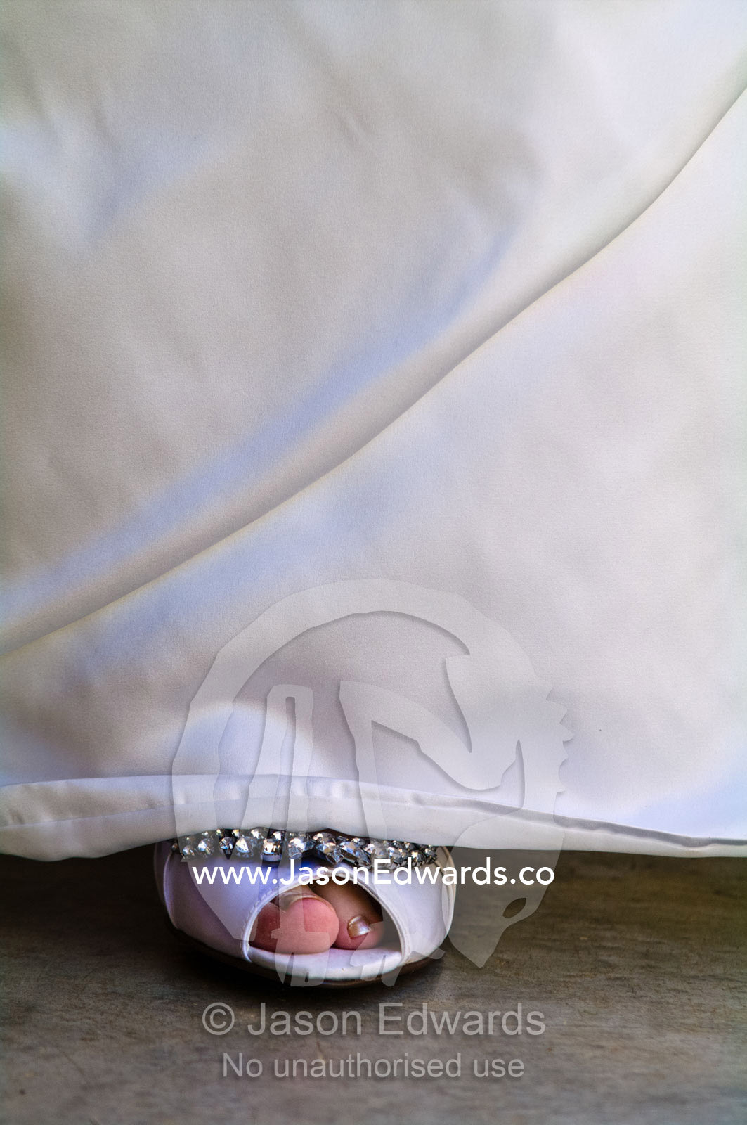 A bride's shoe and toes visible beneath the hem of her wedding dress. Park Orchards, Melbourne, Victoria, Australia.