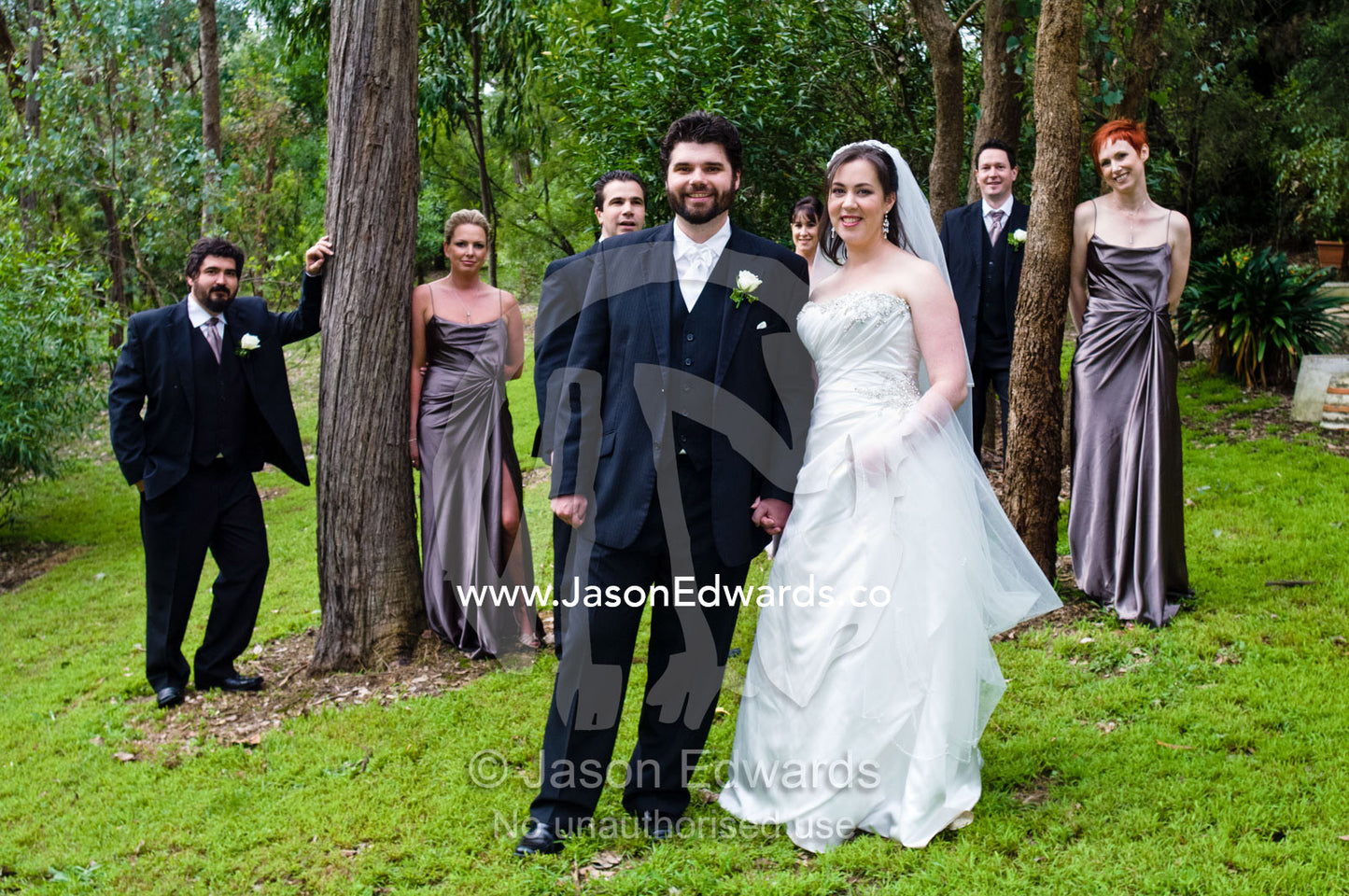 A bride and groom pose with their bridal party at the garden wedding. Park Orchards, Melbourne, Victoria, Australia.