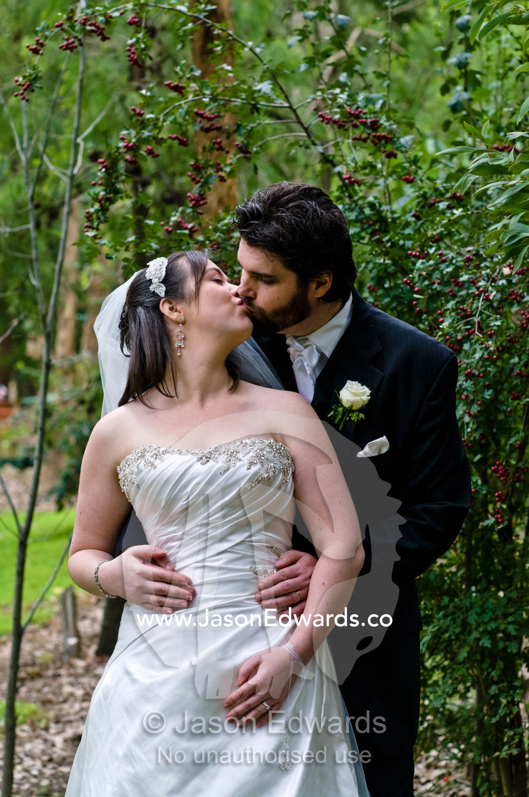 A bride and groom kissing in a garden on their wedding day. Park Orchards, Melbourne, Victoria, Australia.