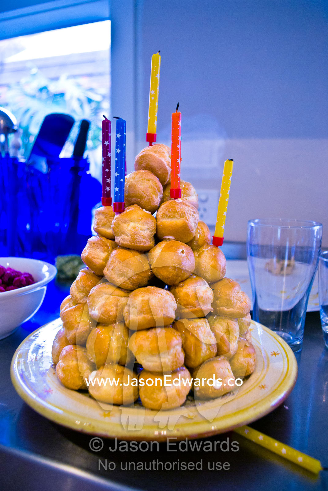 A cone-shaped croquembouche cake with birthday candles on it's summit. Malvern East, Melbourne, Victoria, Australia.
