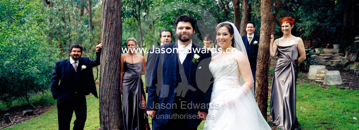 A bride and groom pose with their bridal party at the garden wedding. Park Orchards, Melbourne, Victoria, Australia.