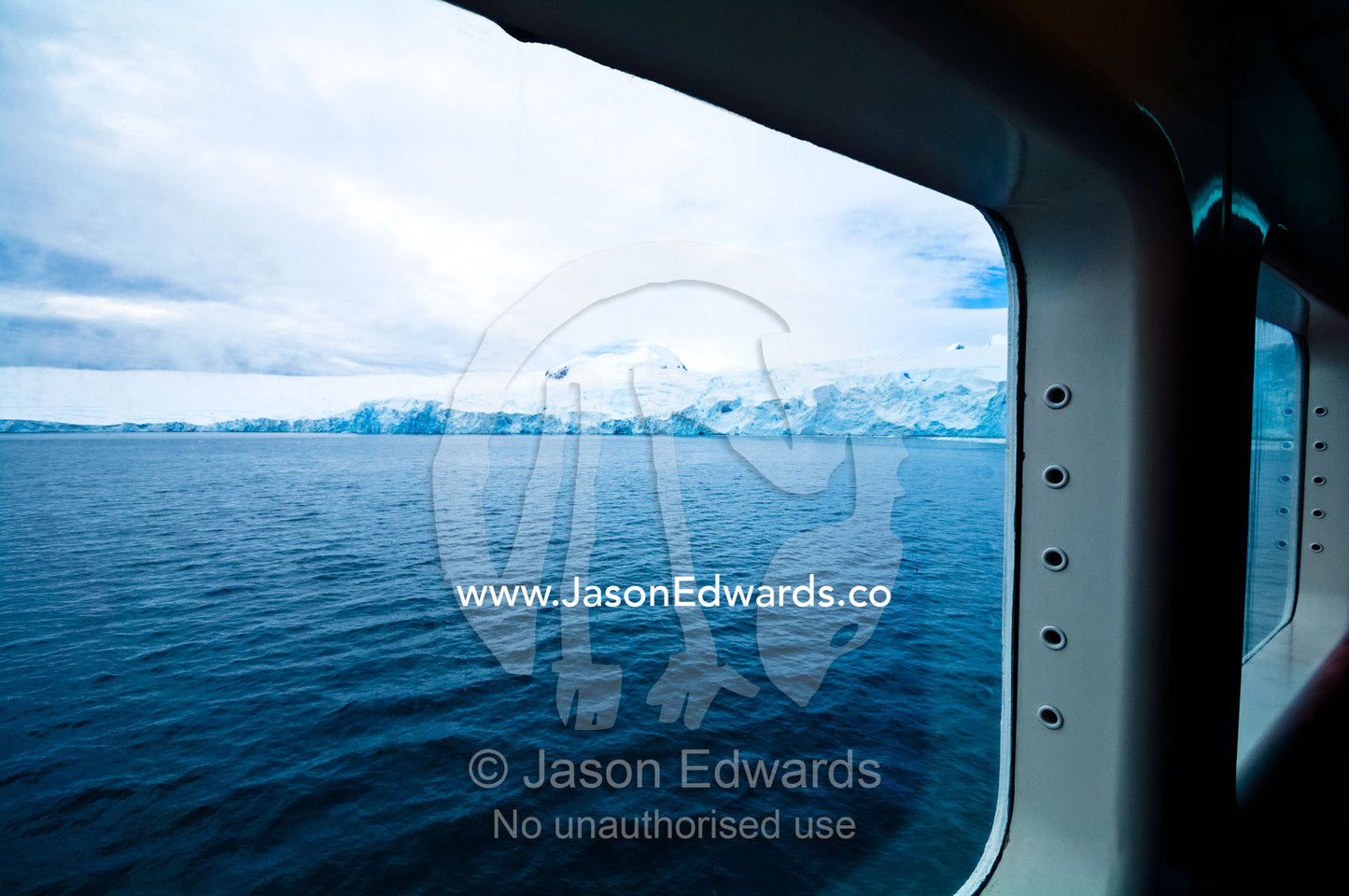 Rugged glacier ice cliffs viewed from the warmth of a ship's window. Prospect Point, Crystal Sound, Antarctic Peninsula, Antarctic Circle, Antarctica.
