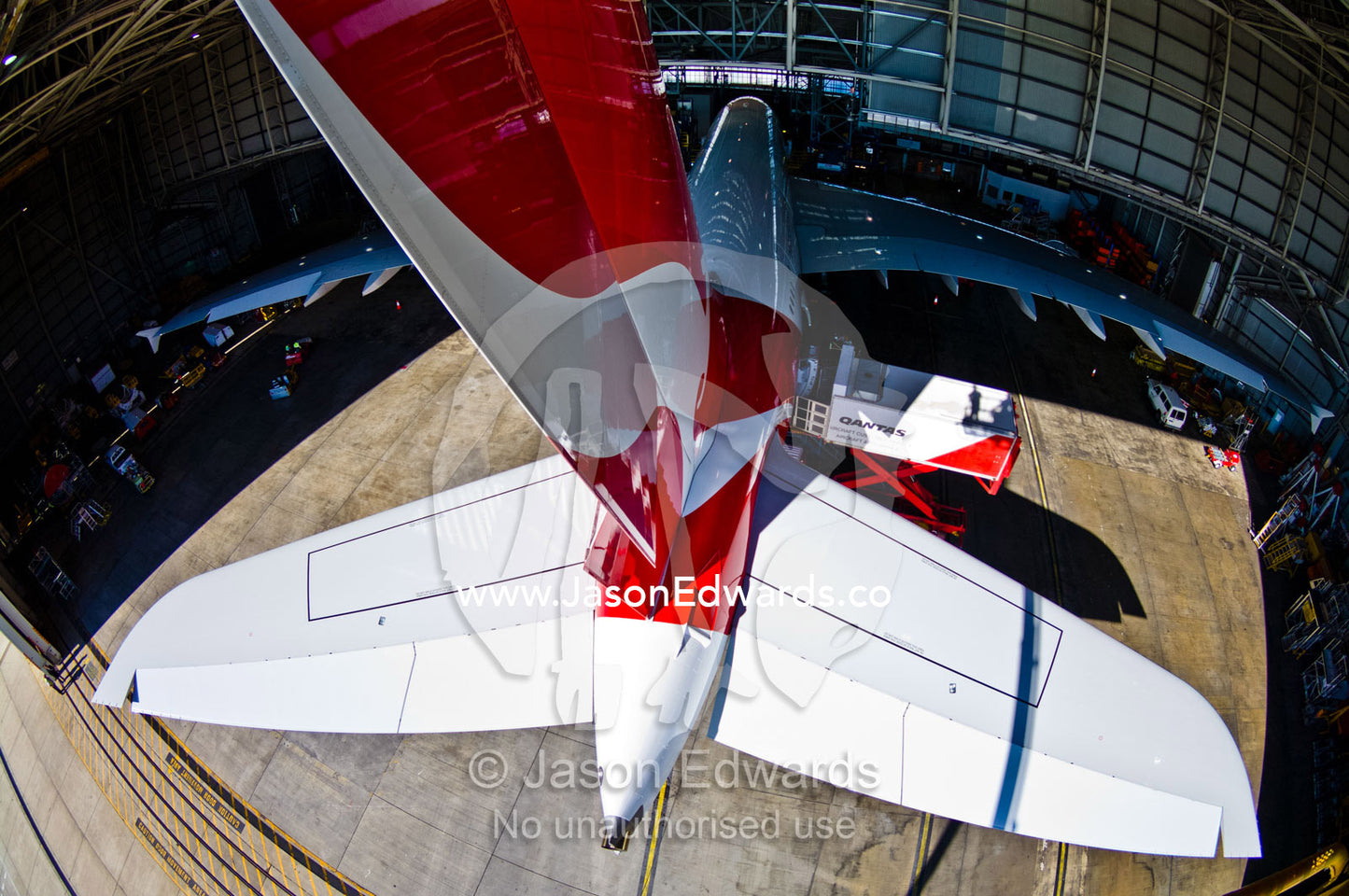 A jet airliner parked in a airport hanger for maintenance repairs. Kingsford Smith Airport, Mascot, Sydney, New South Wales, Australia.