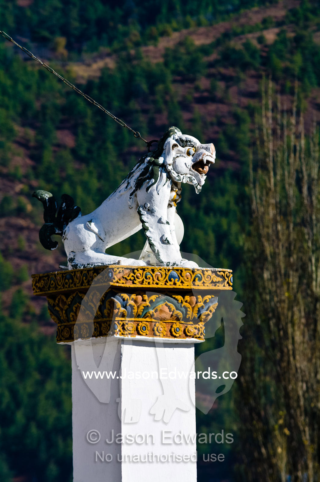 A snow lion statue perched on top of a pillar guards the Thimphu Memorial Chorten. Thimphu Memorial Chorten, Thimphu, Bhutan.
