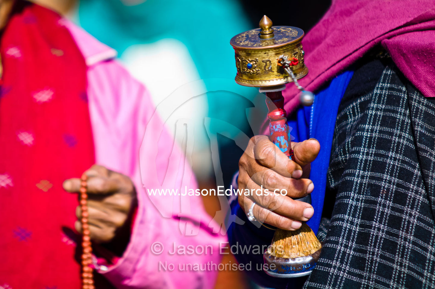 An elderly lady walks in circles around the Thimphu Memorial Chorten spinning her prayer wheel. Thimphu Memorial Chorten, Thimphu, Bhutan.