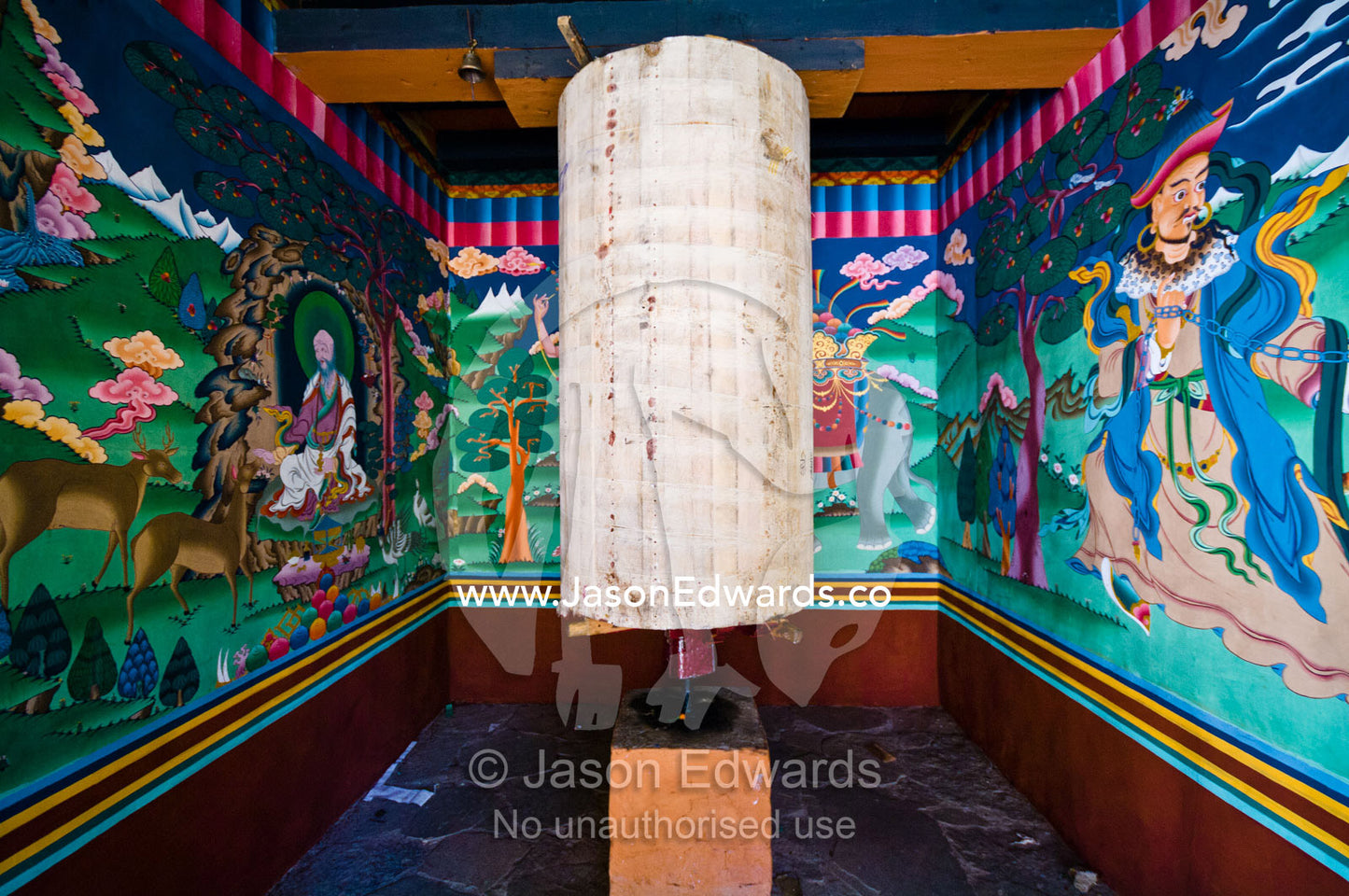 The inner cloth layer of a prayer wheel undergoing construction surrounded by religious murals. Pangri Zampa Astrology School, Thimphu, Thimphu District, Bhutan.