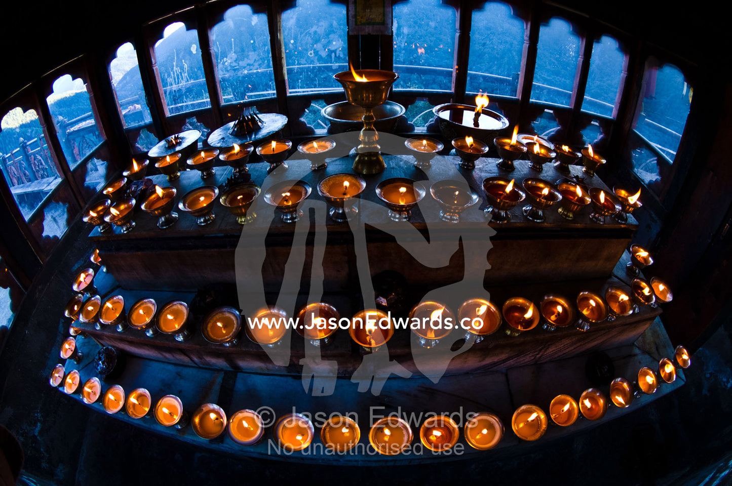 Tiered steps in a Himalayan Buddhist monastery lined with rows of butter lamps for prayers and worship. Cheri Monastery, Chagri Dorjeden Monastery, Thimphu, Thimphu District, Bhutan.