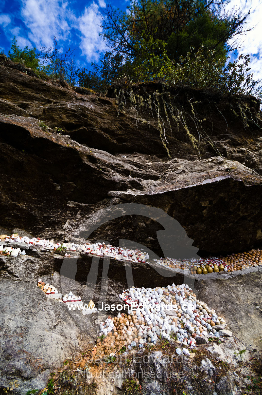 People place religious reliquaries or tsa tsa on a cliff in a Himalaya valley in memory of deceased loved ones. Dochula Pass, Thimphu District, Bhutan.