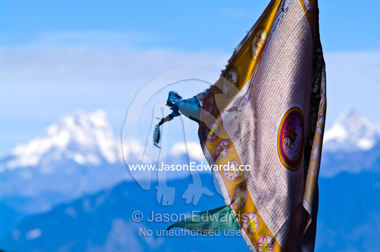 A shiny gold and bronze embossed flag on a Himalayan mountaintop. 108 Druk Wangyal Khangzang Chortens, Dochula Pass, Thimphu District, Bhutan.