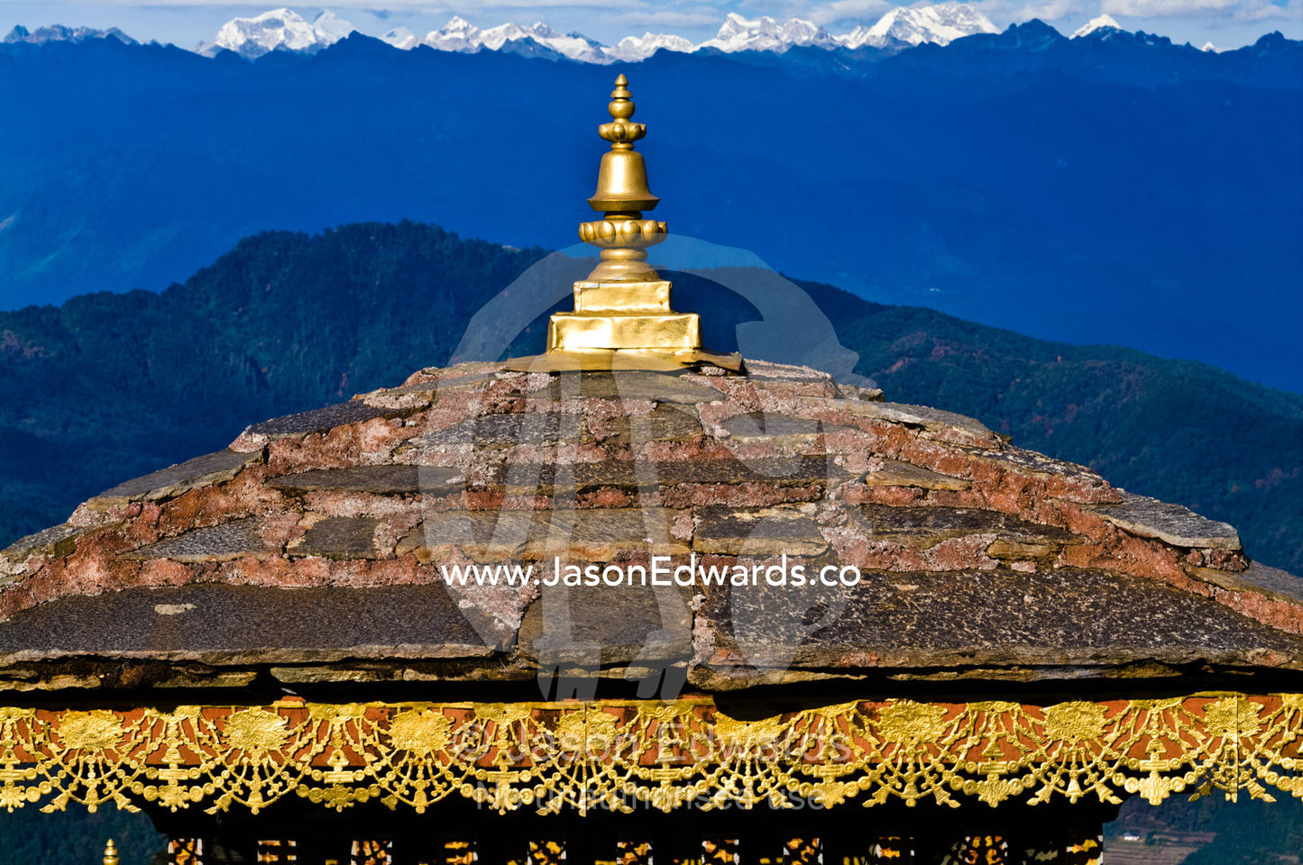 The tiled roof and golden spire of a chorten overlooking the Himalaya. 108 Druk Wangyal Khangzang Chortens, Dochula Pass, Thimphu District, Bhutan.