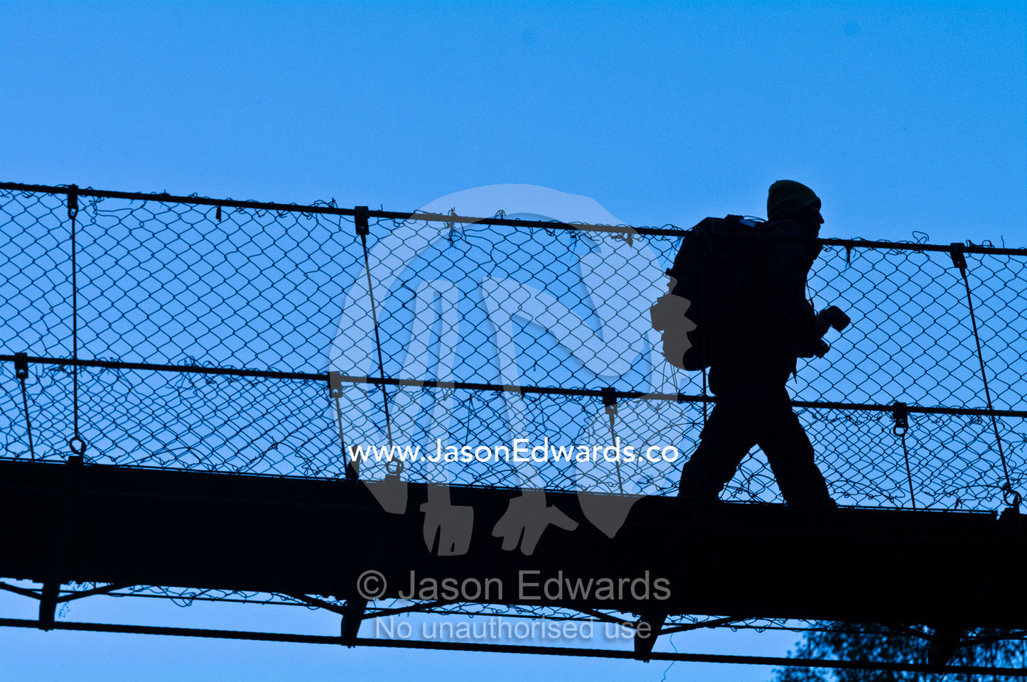 The silhouette of a Bhutanese guide crossing a suspension bridge over a river gorge. Pho Chu, Pho River, Gasa Dzong, Gasa Tashi Tongmon Dzong, Gasa Gasa Dzongkhag District, Bhutan.