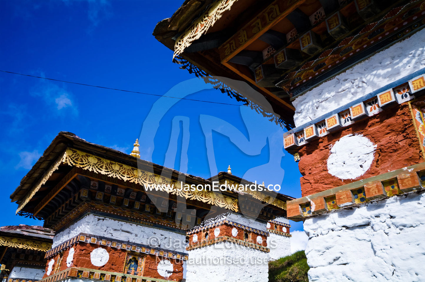 Ornately decorated eaves beneath the tiled roofs of chortens. 108 Druk Wangyal Khangzang Chortens, Dochula Pass, Thimphu District, Bhutan.