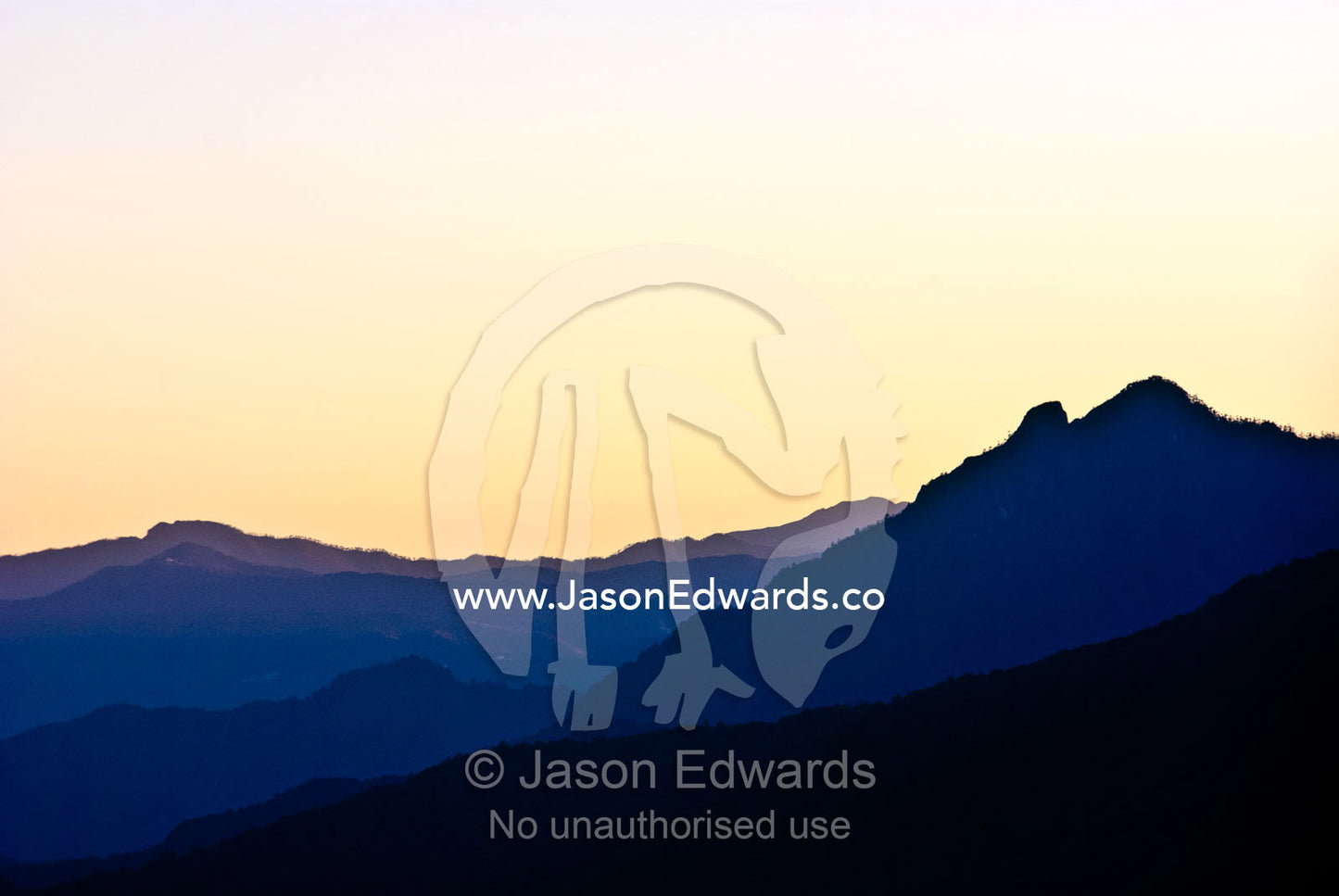 The sunset afterglow casts shadows of varying intensity over folded mountain ranges in the Himalaya. Jigme Dorji National Park, Gasa District, Bhutan.