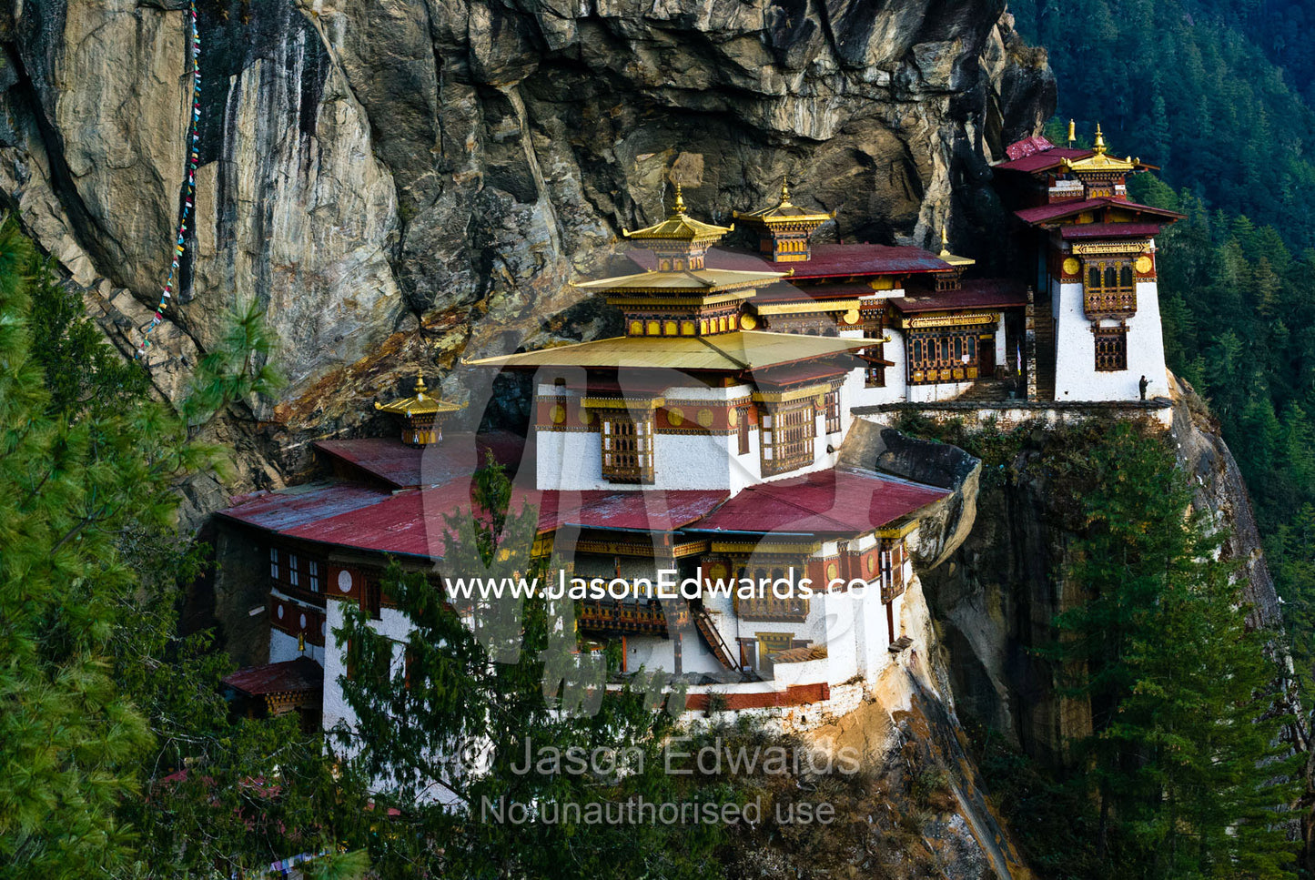 An ancient Buddhist monastery clinging to a sheer cliff on a Himalaya mountainside. Paro Taktsang, The Tigers Nest, Paro Valley, Paro District, Bhutan.