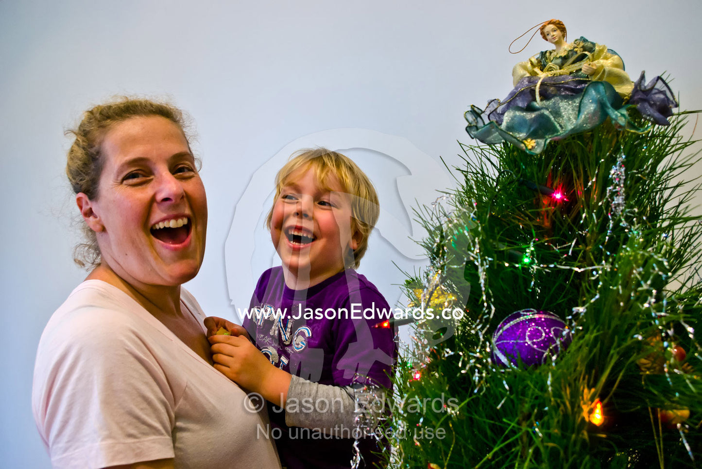 A mother and son decorates a family christmas tree with an angel. Carlton North, Melbourne, Victoria, Australia.