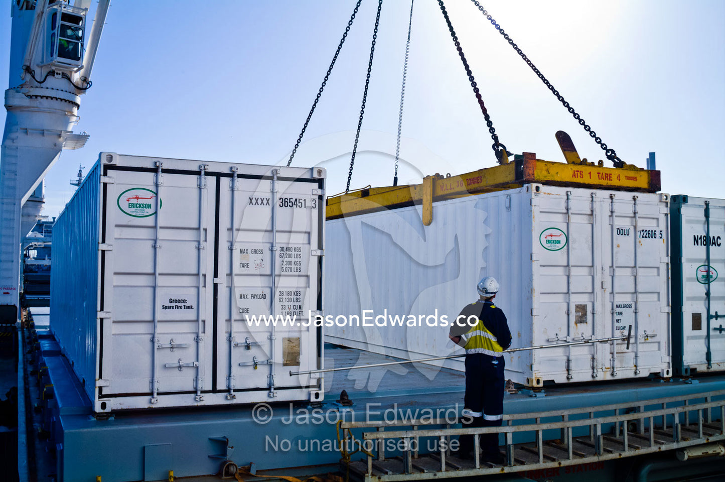 A cargo ships stevedore monitors a crane lifting shipping containers. Appleton Dock, Port of Melbourne, West Melbourne, Victoria, Australia.