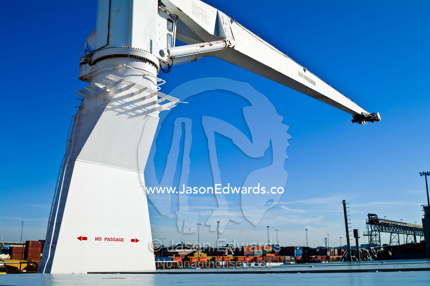 The boom of a ships crane towers over the deck cargo hold. Appleton Dock, Port of Melbourne, West Melbourne, Victoria, Australia.