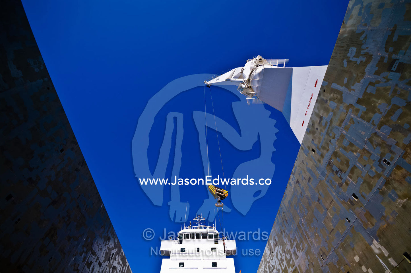 The boom and crane of a ships crane towers over the deck cargo hold. Appleton Dock, Port of Melbourne, West Melbourne, Victoria, Australia.