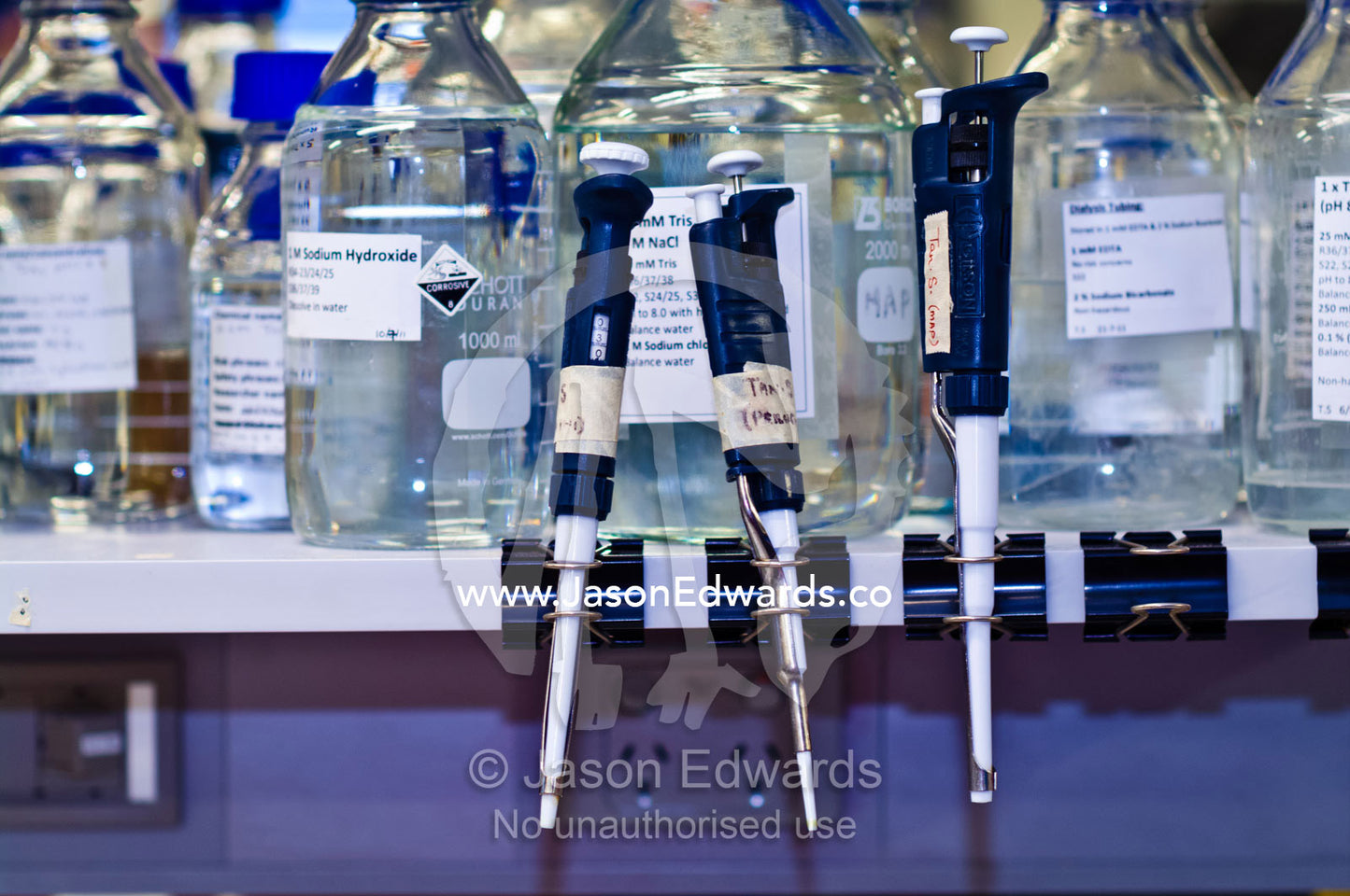 Laboratory pipettors and buffer solutions stored in glass jars. Bio21 Molecular Science and Biotechnology Institute, University of Melbourne, Parkville, Melbourne, Victoria, Australia.