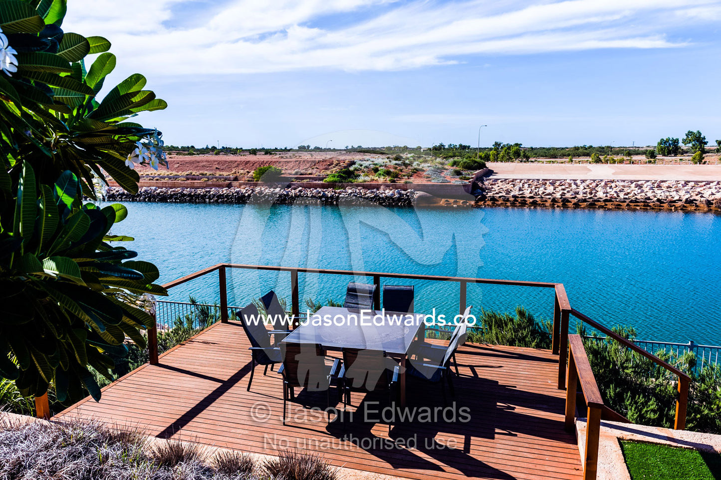 A dining table and chairs on a patio overlooking a mariner estate. Exmouth, Ningaloo Reef, Western Australia, Australia.
