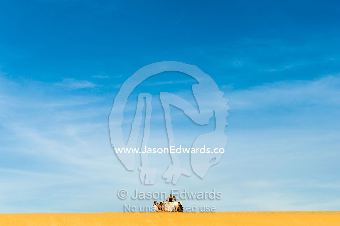 A film crew records an interview on a coastal sand dune at sunset. Cape Range National Park, Exmouth, Ningaloo Reef, Western Australia, Australia.