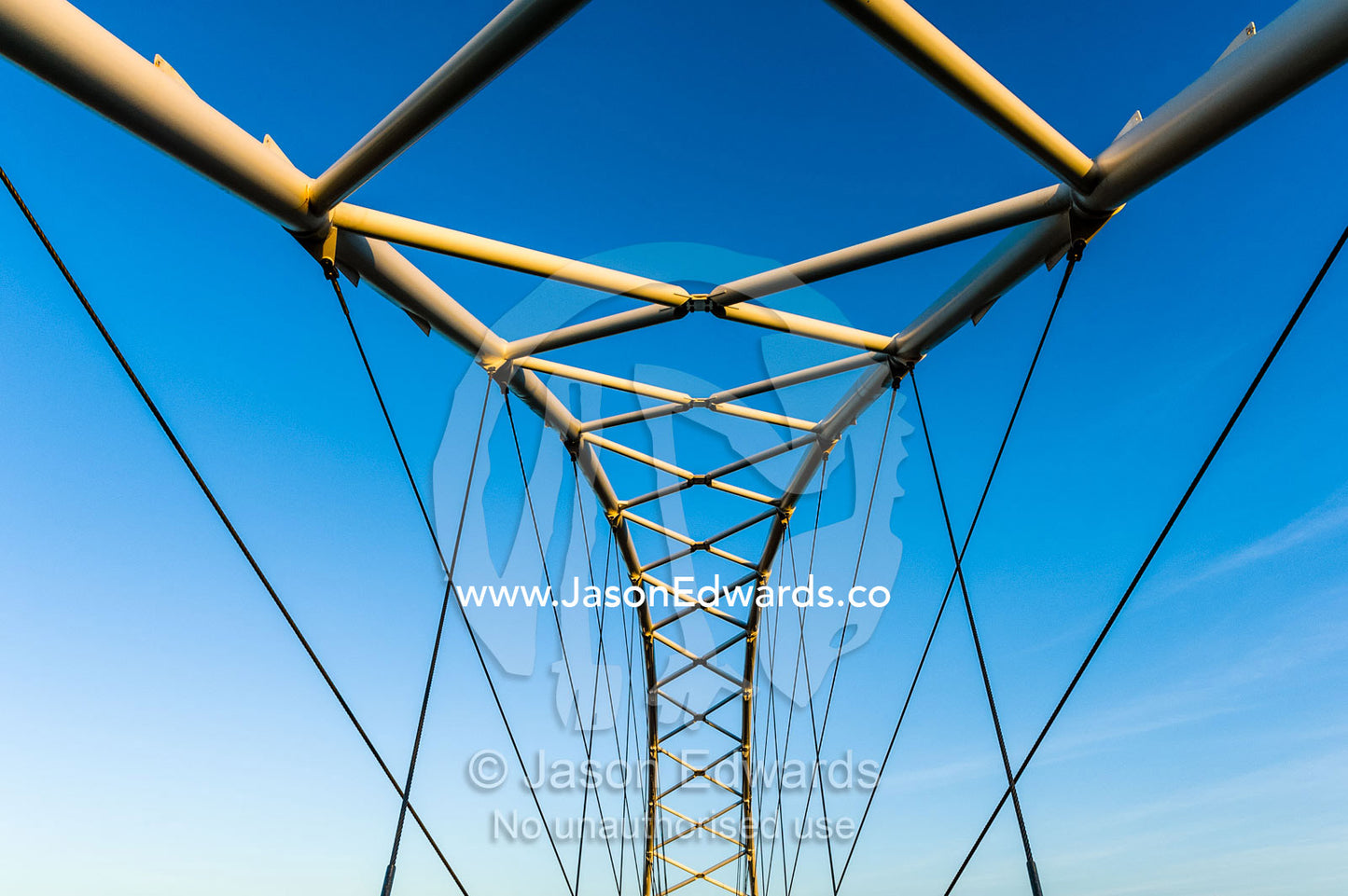 Steel girders of a residential foot bridge arching over a tidal canal. Exmouth, Ningaloo Reef, Western Australia, Australia.