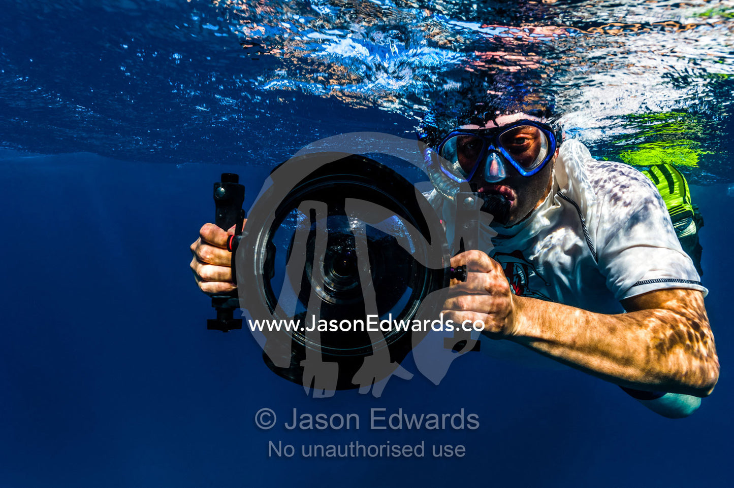 A cameraman snorkeling with a video camera in an underwater housing. Exmouth, Ningaloo Reef, Ningaloo Marine Park, Western Australia, Australia.