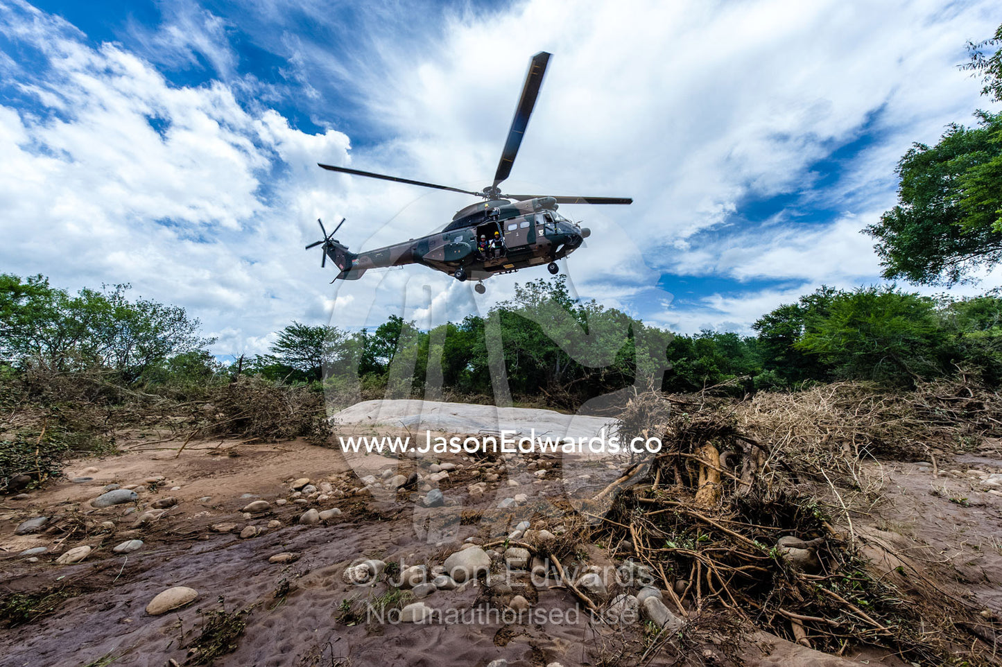 An Atlas Oryx airforce helicopter landing on a flooded river bank. Kruger National Park, South Africa.