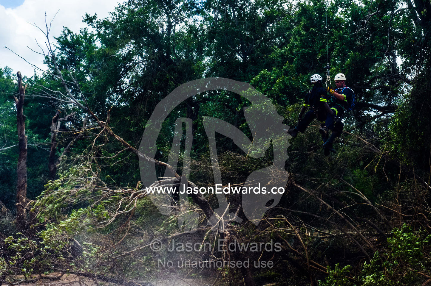 An Airforce and police rescue crew lowered onto a flooded river. Kruger National Park, South Africa.