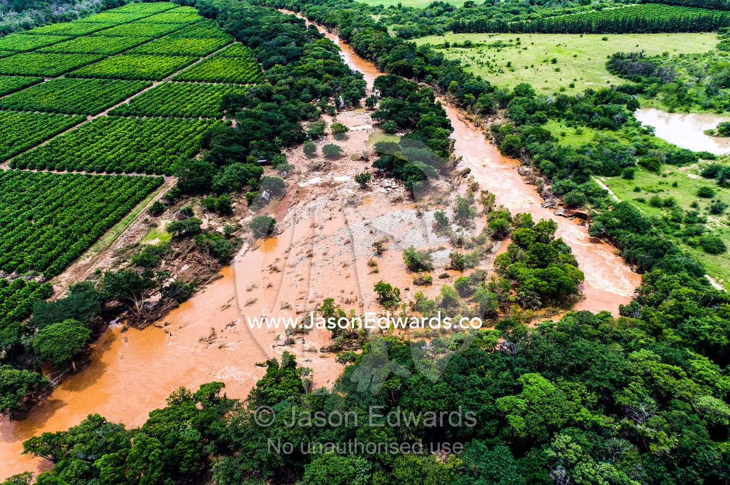 A flooded river narrowly misses destroying an agricultural crop. Kruger National Park, South Africa.