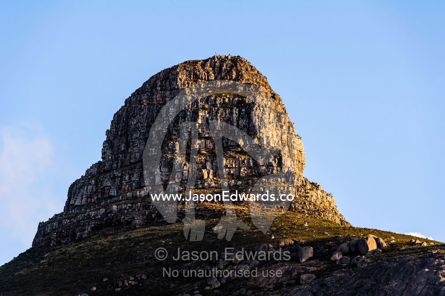 The rugged Lion's Head cliff face rises into the sky over Cape Town. Table Mountain, Cape Town, Cape Peninsula, Western Cape, South Africa.