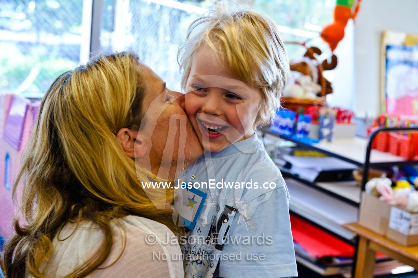 A mother kisses a boy goodbye on his first day of school. Melbourne, Lee Street Primary School, Carlton North, Melbourne, Victoria, Australia.