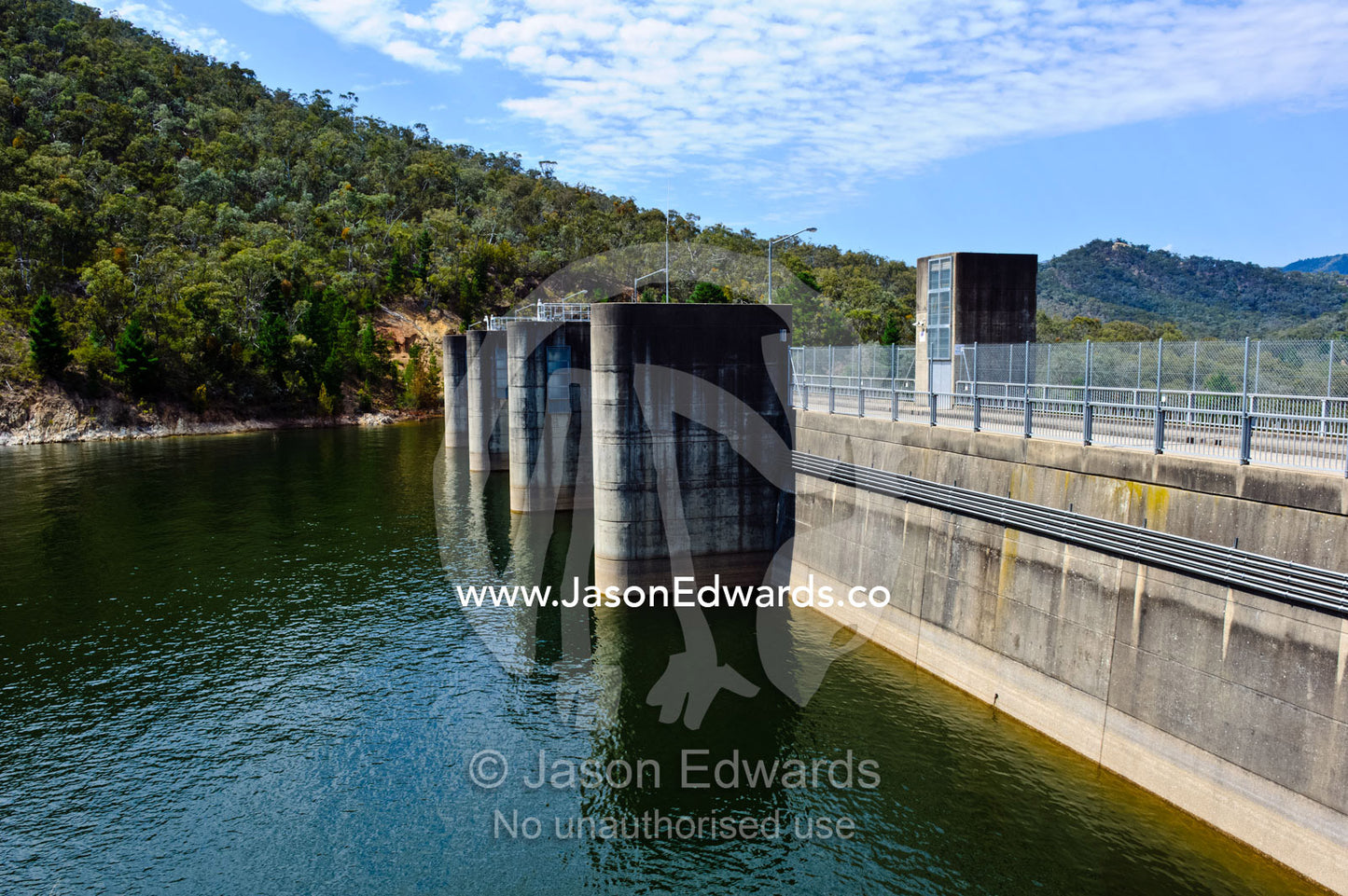 A city water catchment dam wall and spillway gates filled with water. Lake Eildon, Eildon Weir Spillway, Victoria, Australia.