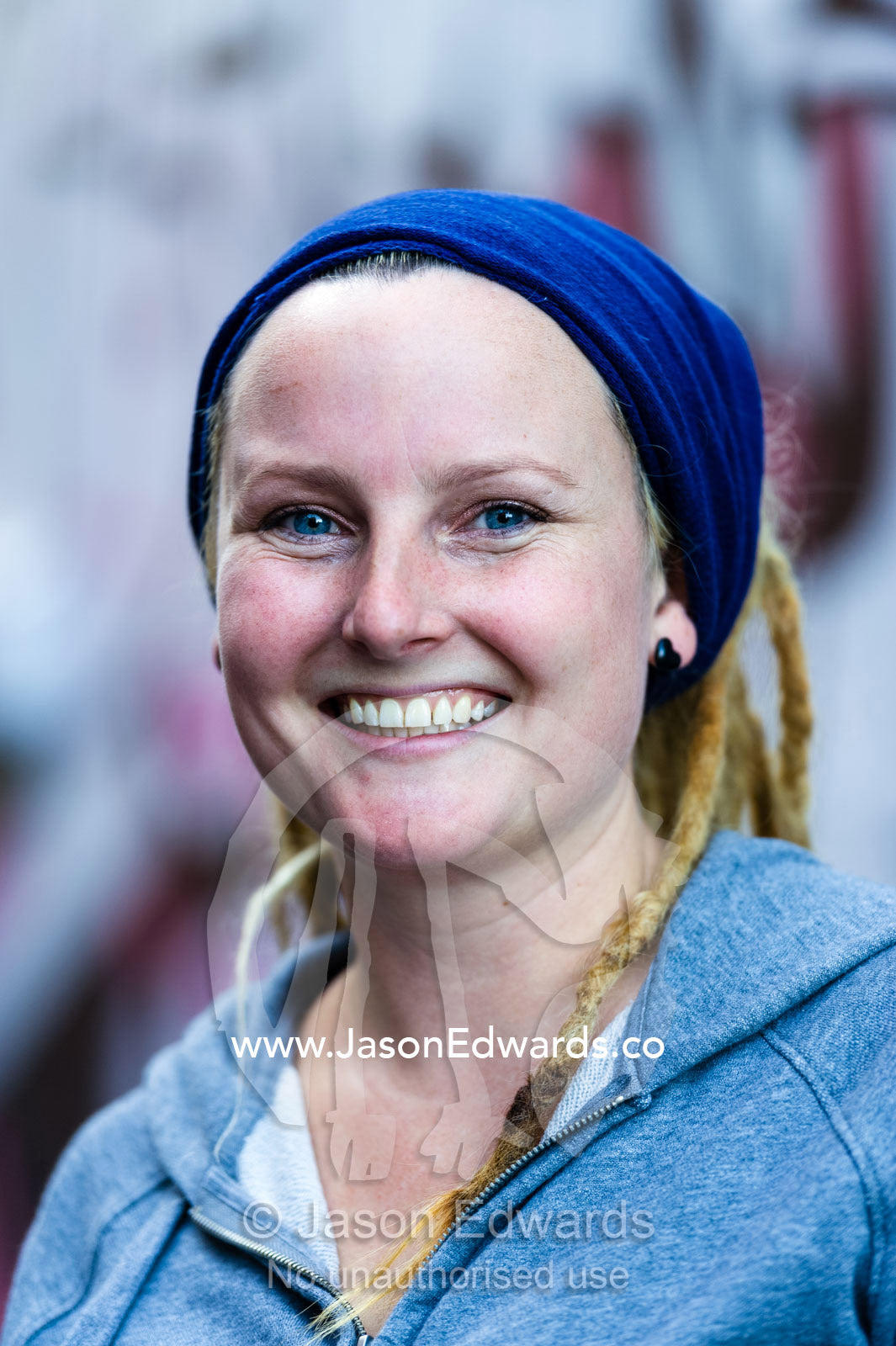 A healthy young woman with dreadlocks smiles at the camera. Collingwood, Melbourne, Victoria, Australia.