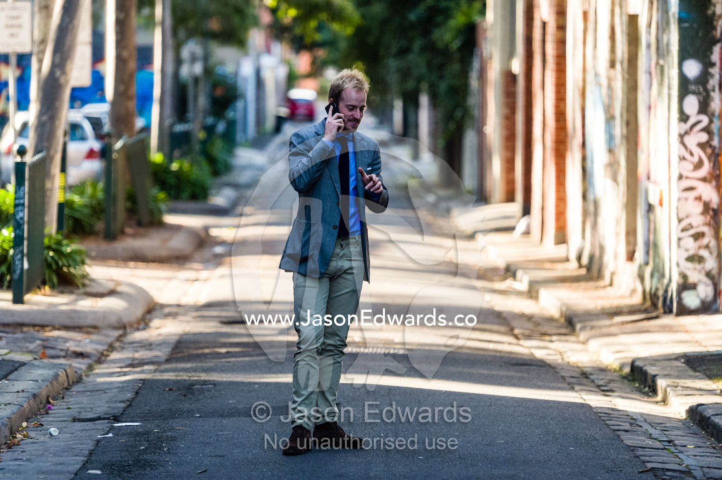 A real estate agent conducting a business meeting on a smart phone. Collingwood, Melbourne, Victoria, Australia.