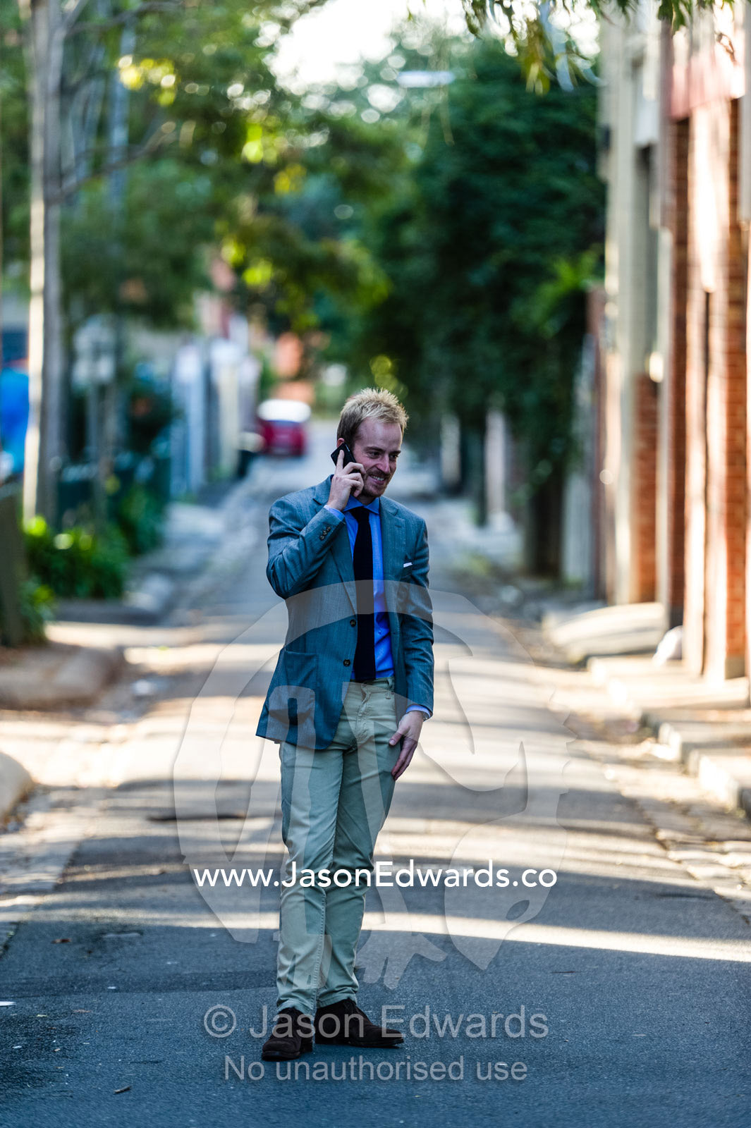 A real estate agent conducting a business meeting on a smart phone. Collingwood, Melbourne, Victoria, Australia.