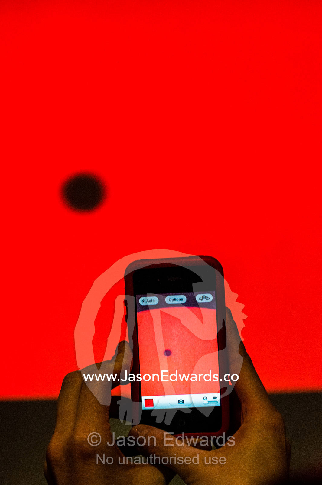 A smart phone captures Venus passing the sun on a planetarium monitor. Melbourne, Victoria, Australia.