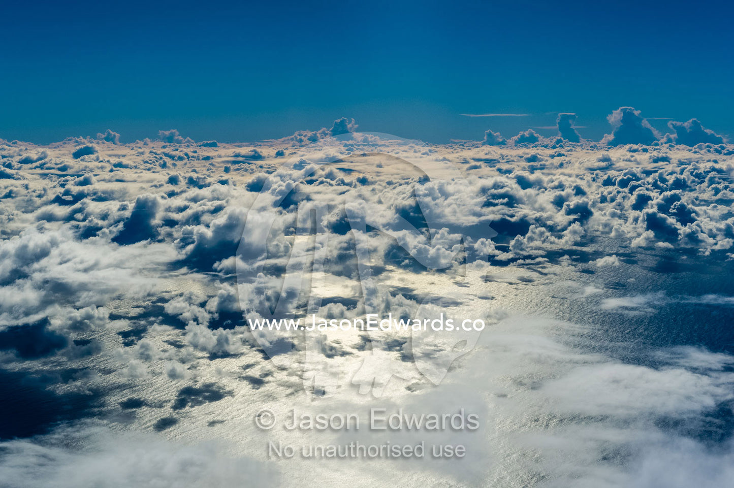 Sunshine pierces clouds reflecting off the ocean surface. Auckland, New Zealand.