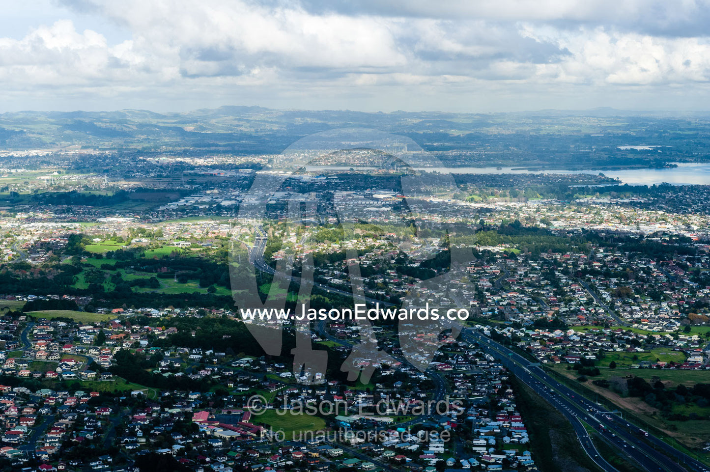 Sprawling suburbs and residential estates dissected by a freeway. Auckland, New Zealand.