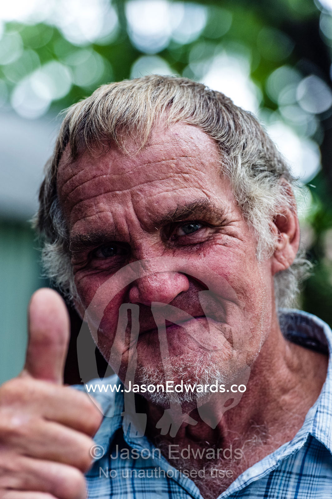 A man gives a thumbs-up in a displaced community outside Pretoria. Bon Accord Dam, Gauteng Province, South Africa.
