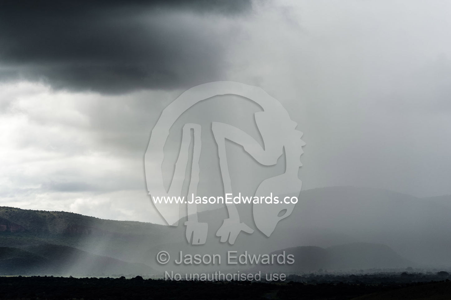 A torrential rainstorm shrouds rolling hills and farmland in grey. Route 101, Naboomspruit, Modimole, Limpopo, South Africa.