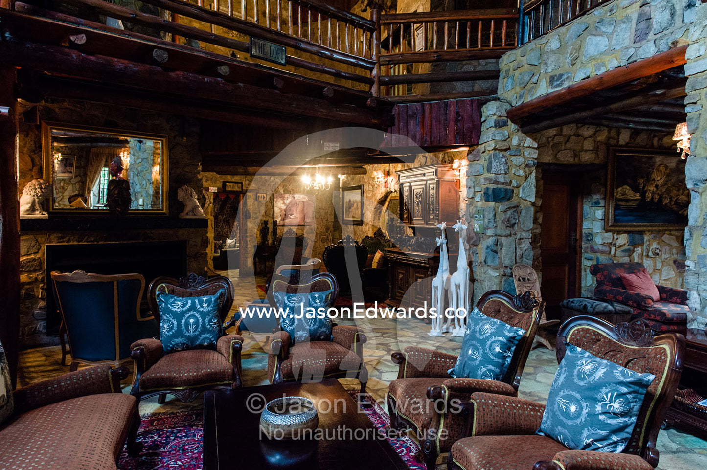 An elegant stone and timber sitting room in an African safari lodge. The Farm Inn, Pretoria, Gauteng Province, South Africa.