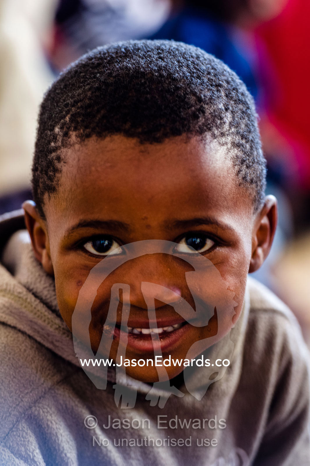 A happy boy enjoys working on the alphabet whilst attending school. Red Hill Township and Pre-School, Cape Town, Western Cape, South Africa.