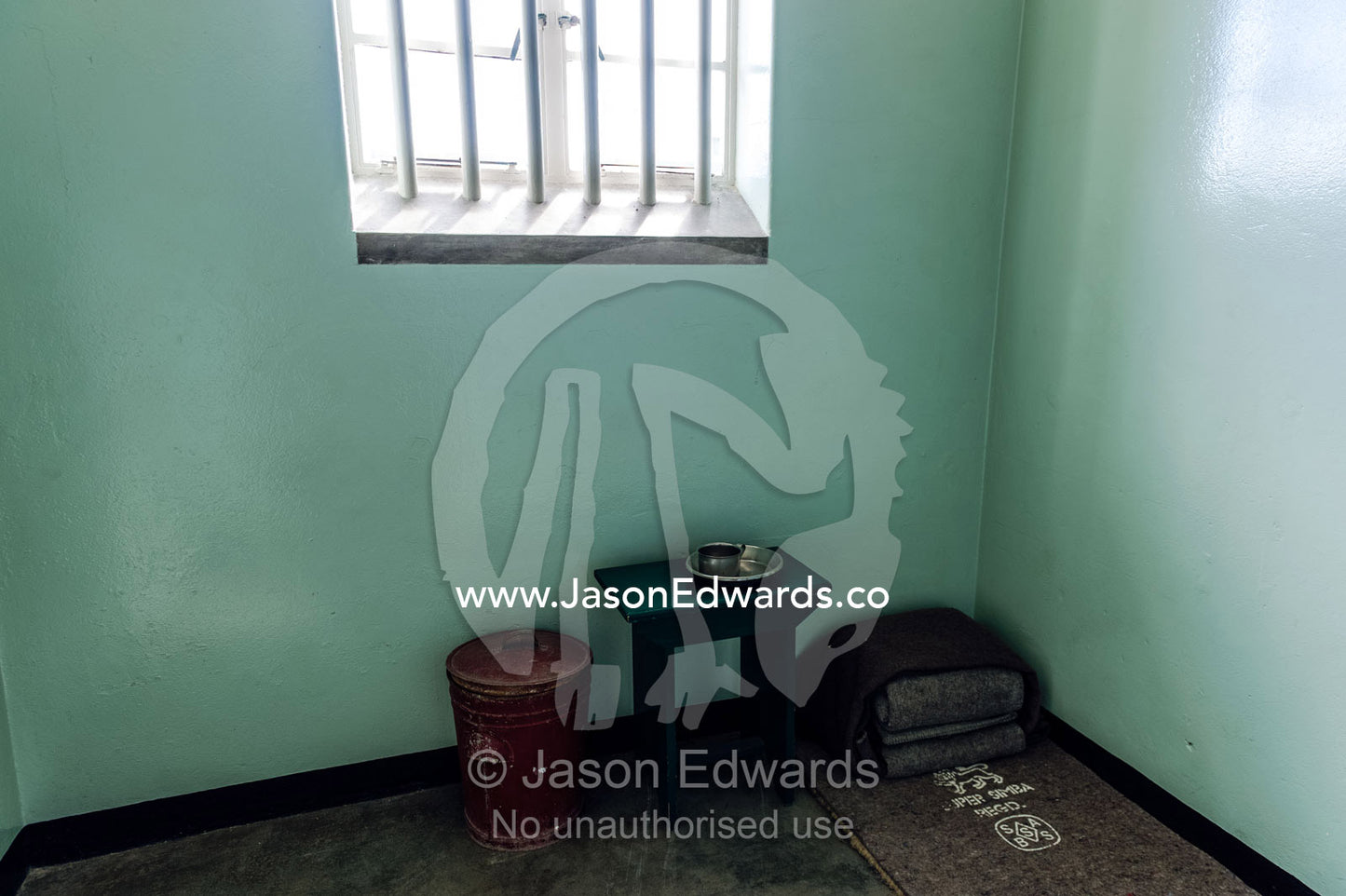 A cup, bowl and bed roll in the cell inhabited by Nelson Mandela. Robben Island, Cape Town, Bloubergstrand, Table Bay, Western Cape, South Africa.