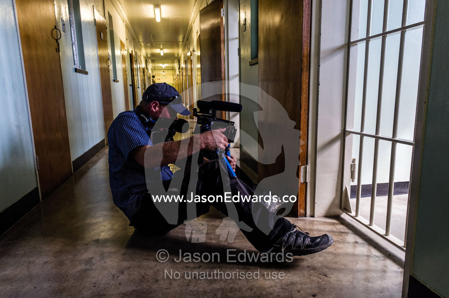 A cameraman films the prison cell inhabited by Nelson Mandela. Robben Island, Cape Town, Bloubergstrand, Table Bay, Western Cape, South Africa.
