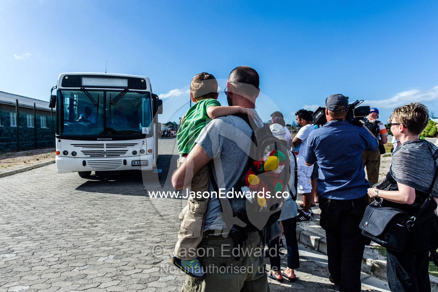 Tourists wait to board a bus for a tour of Robben Island prison. Robben Island, Cape Town, Bloubergstrand, Table Bay, Western Cape, South Africa.